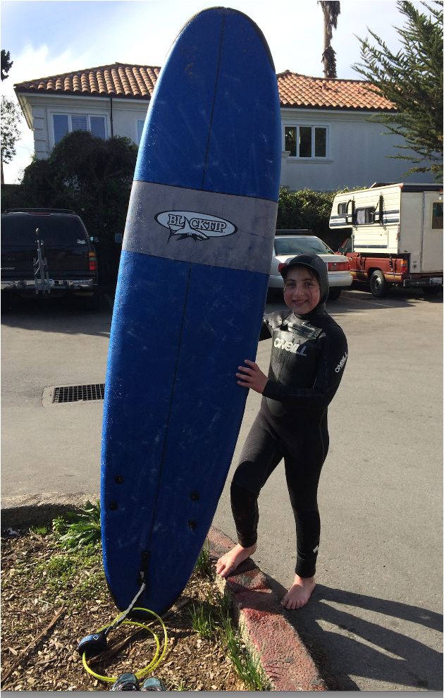Emily Judith Mitnick holding a surfboard after getting out of the ocean.