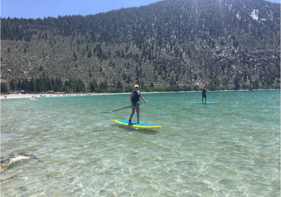 Emily Judith Mitnick in control on SUP at a beautiful lake with transparent water.